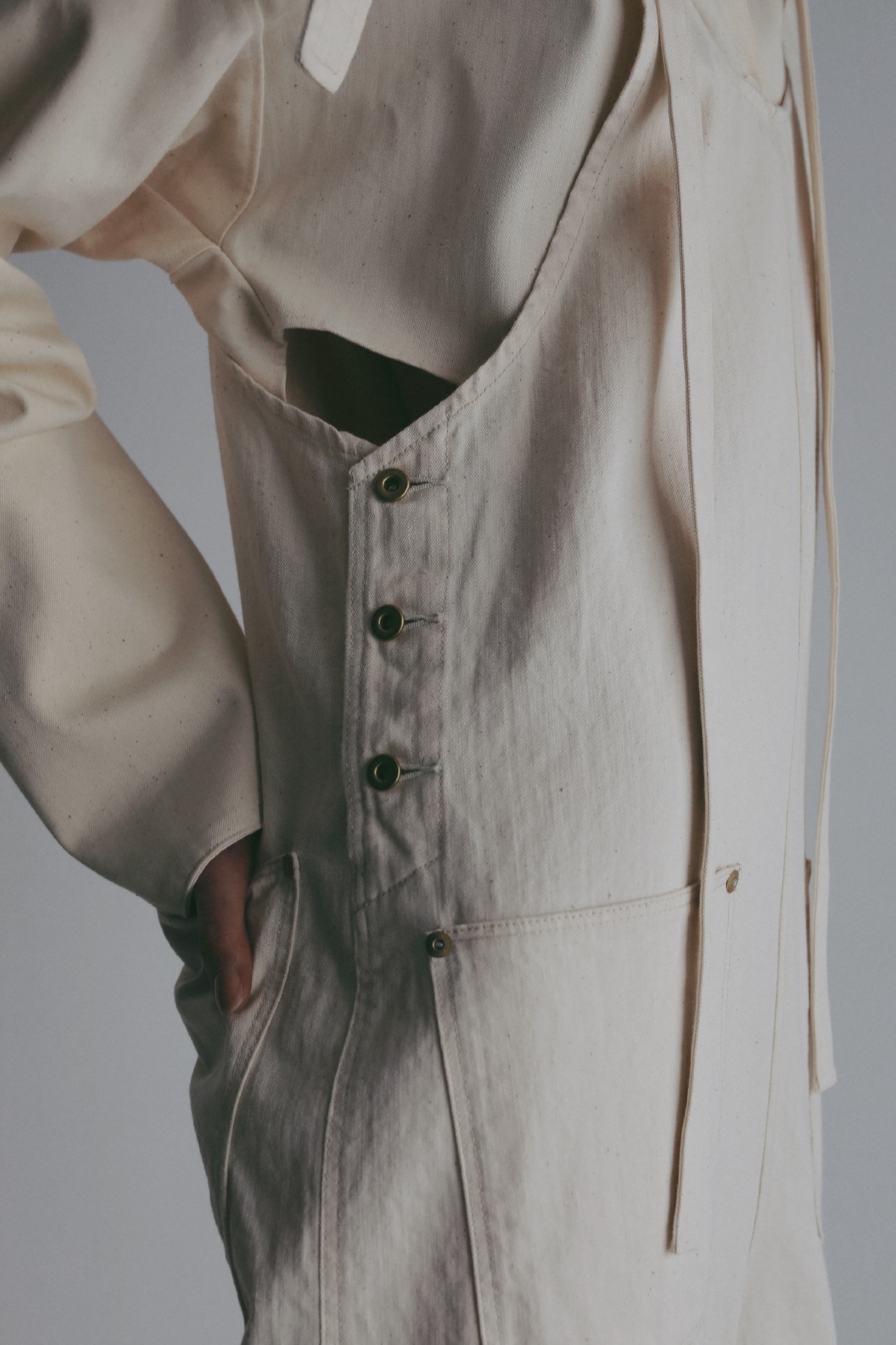 ホワイトのジャケット・ホワイトのオールインワンを着用した女性のアップの画像