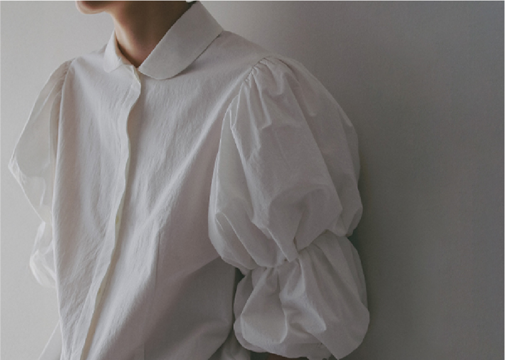 ホワイトのブラウスを着用した女性のアップの画像