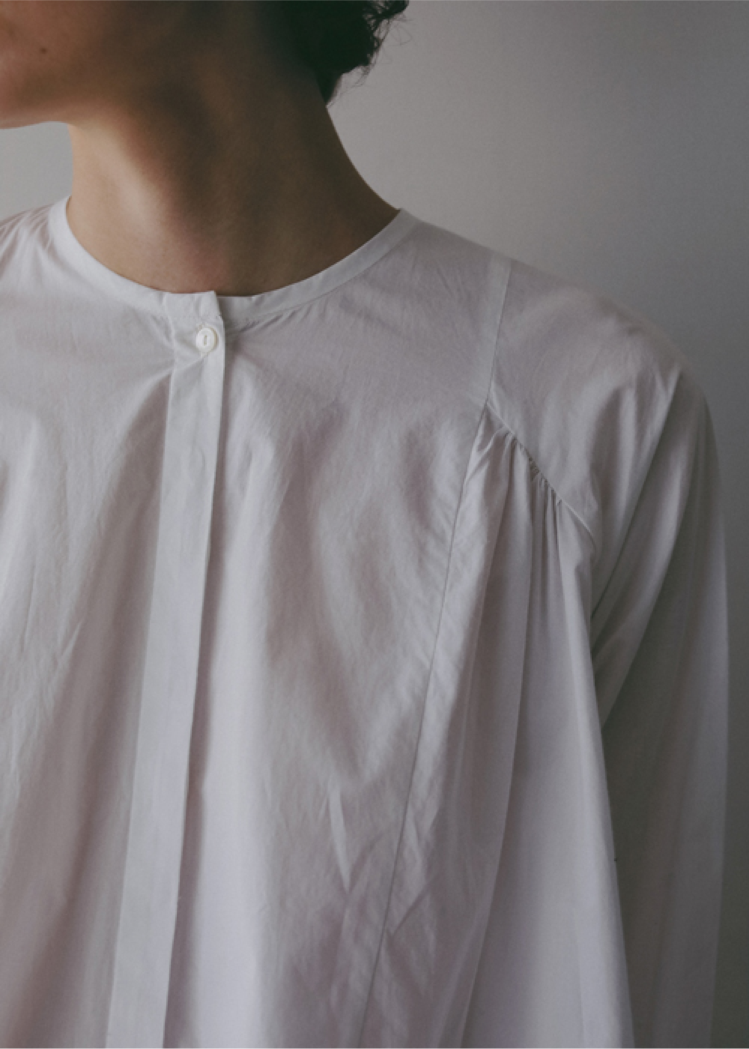 ホワイトのブラウスを着用した女性のアップの画像