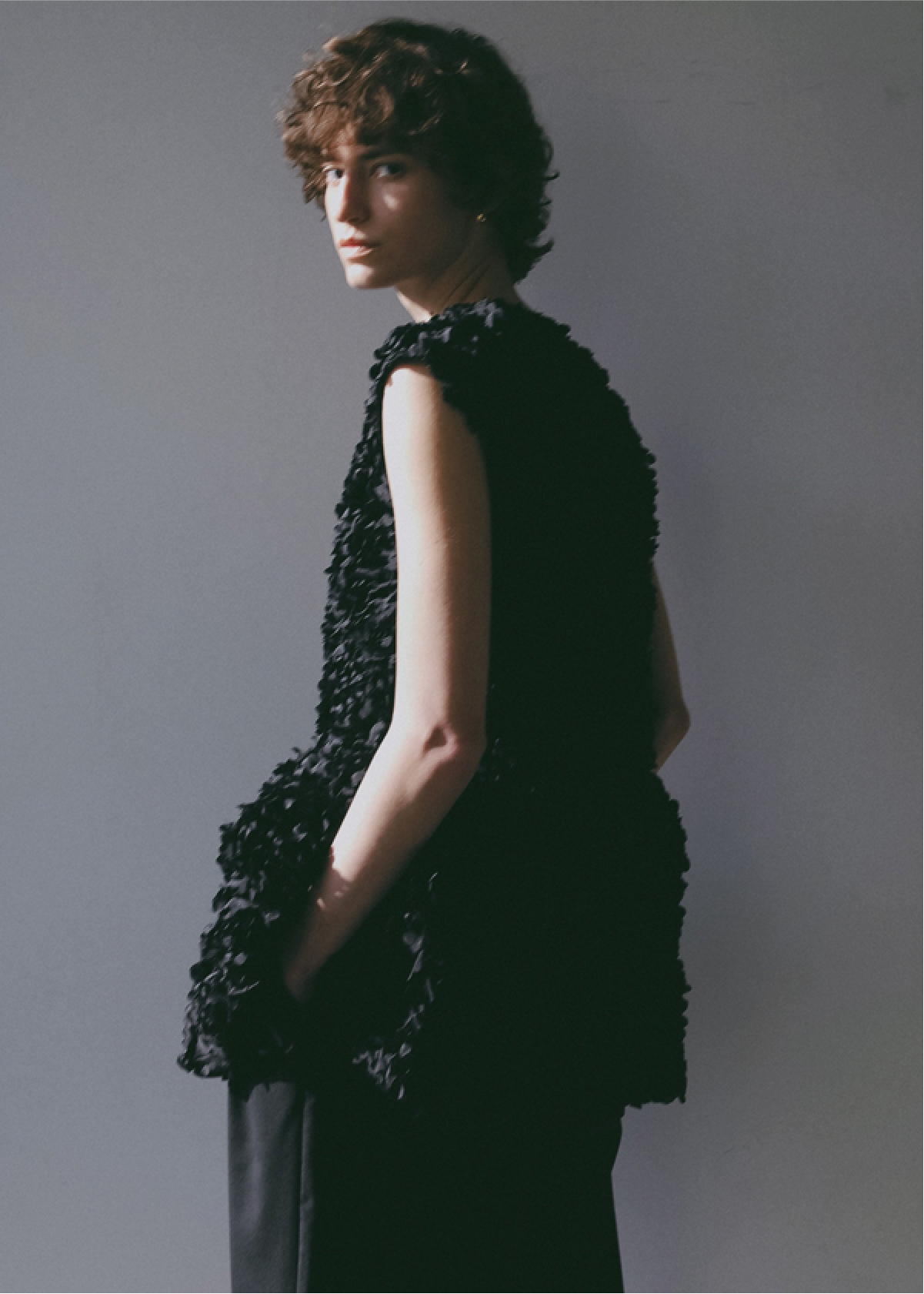 ブラックのブラウス・ブラックのパンツを着用した女性の画像